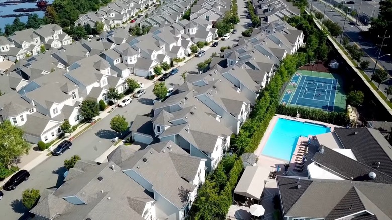 Aerial view of white homes, a pool, and a tennis court in Staten Island