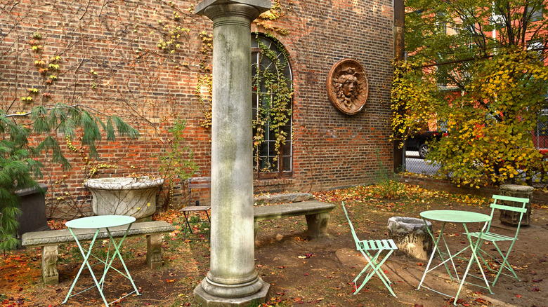 A cozy corner of Elizabeth Street Garden with a column and tables
