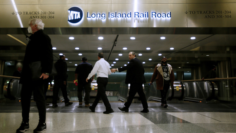 Several people walk through a Long Island Rail Road station