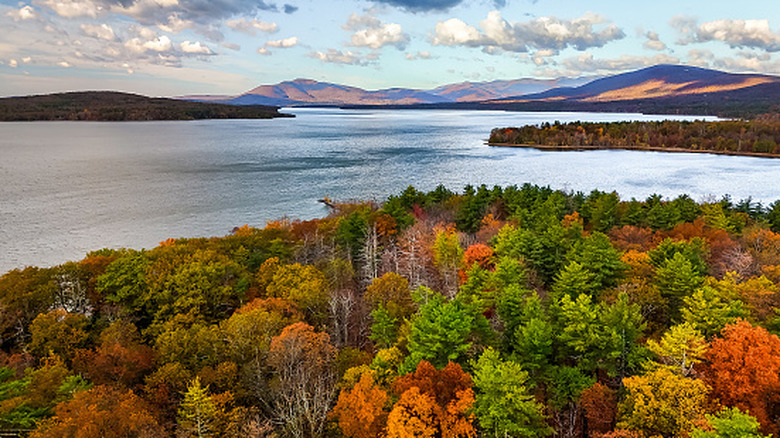 Aerial view of the Ashokan Reservoir at sunrise, capturing vibrant autumn foliage in shades of gold