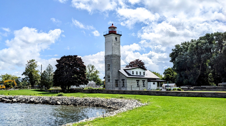 The Ogdensburg Harbor Lighthouse with grassy lawn and water