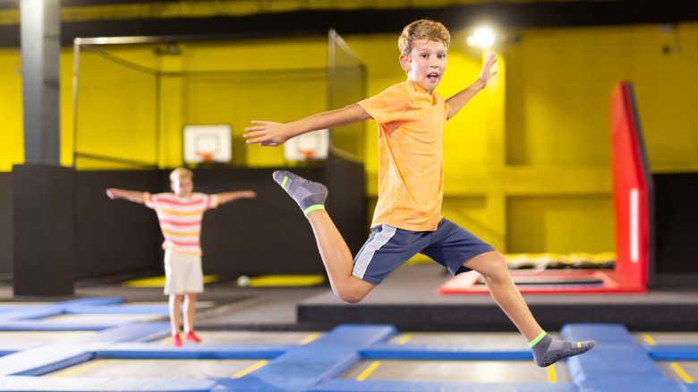 Children bounce around an indoor trampoline play area