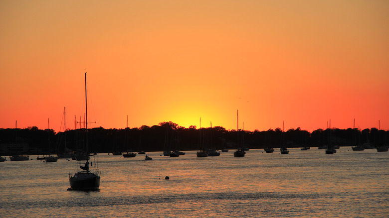 Sunset over Manhasset Bay in Port Washington, with boats docked along the shore