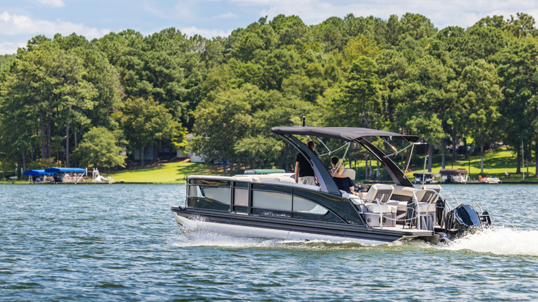 Pontoon boat on the lake in summer with shoreline views