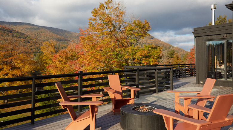 the outdoor terrace of a hotel with a firepit and chairs