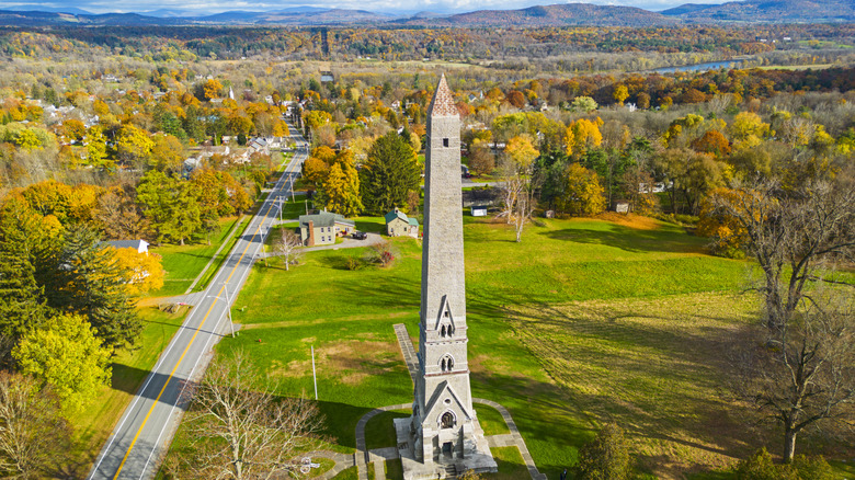 Saratoga Monument surrounded by fall foliage and mountains