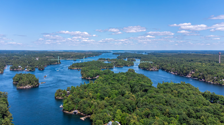Aerial view of St. Lawrence River and Thousand Islands region, where blue water weaves between irregular islands.