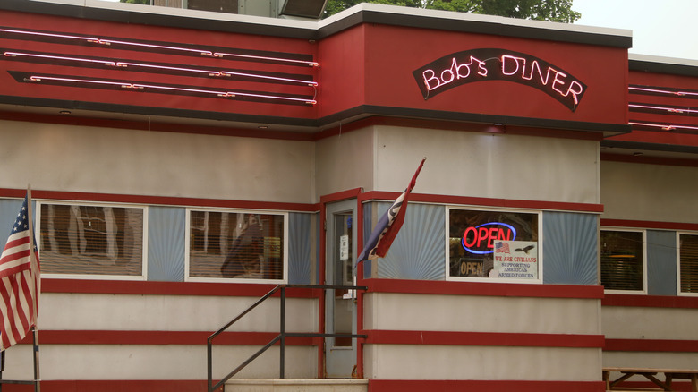 The exterior of a retro diner with a neon sign reading Bob's Diner in Bainbridge, New York