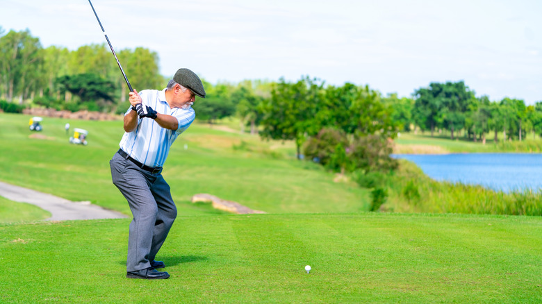 an elderly man plays golf
