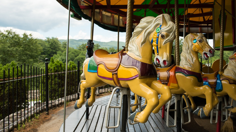 Sideview shot of a vintage yellow carousel horse against cloudy skies