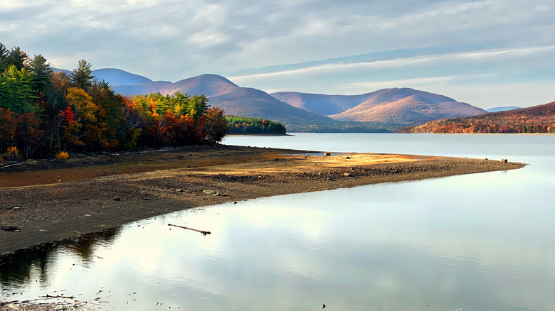 The Catskill Mountains and fall leaves surround Ashokan Reservoir in Shokan, New York.