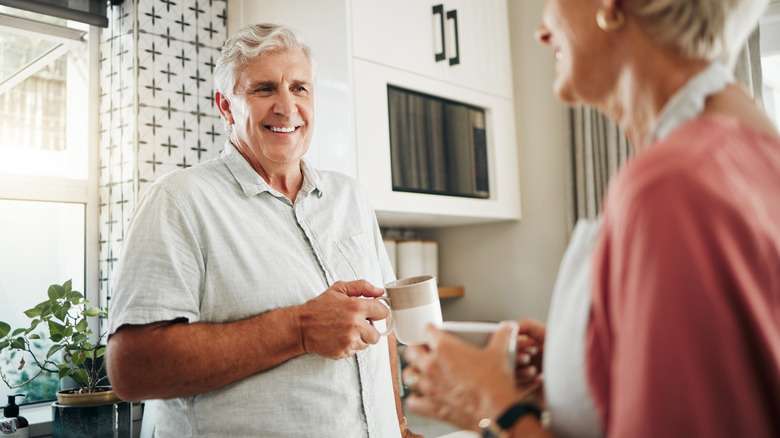 A smiling older man and woman in kitchen