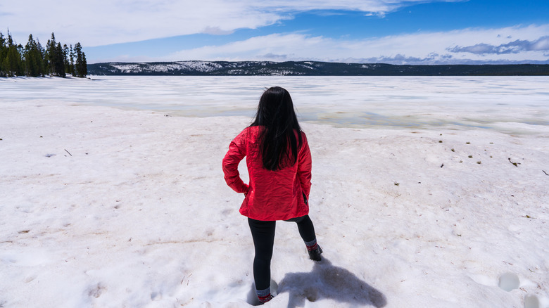 Hiker looking at the frozen Yellowstone Lake in Yellowstone National Park