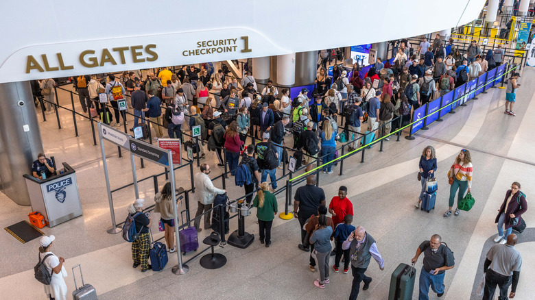 A large crowd of people waiting at the security checkpoint at Charlotte Douglas International Airport.