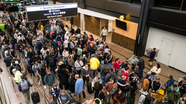 A large crowd of people lining up for the security checkpoint at Seattle-Tacoma International Airport.