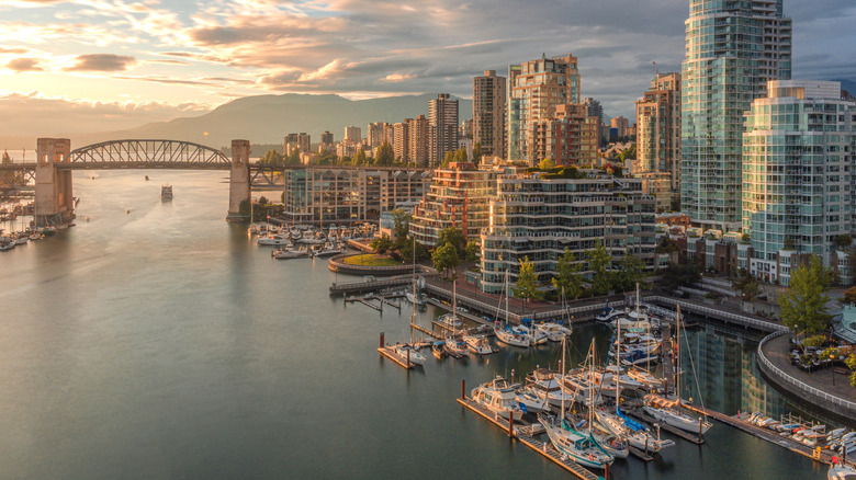 A marina, contemporary glass skyscrapers, and a steel bridge at sunset in Vancouver