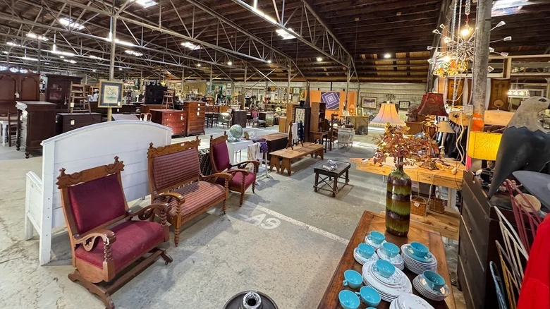 An antique warehouse booth filled with furniture, shelves, paintings, and chairs in Asheville, North Carolina.