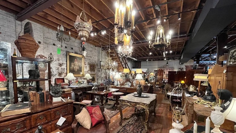 The interior of Village Antiques and Interiors packed with chandeliers, paintings, and furniture.
