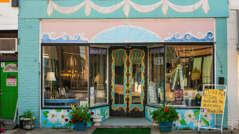 A brightly painted shopfront in Downtown Selma with artistic flowers and antique goods in the windows.