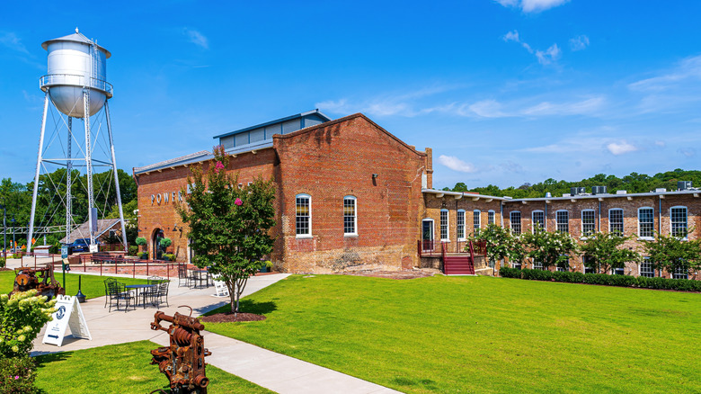 green grass and manicured bushes in front of Rocky Mount Mills