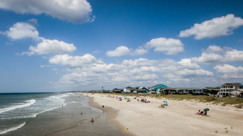 Visitors lounging on the white sand beach at Oak Island, North Carolina