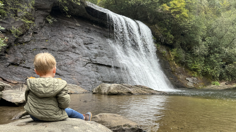 Little boy sitting at Silver Run Falls in Cashiers, North Carolina.