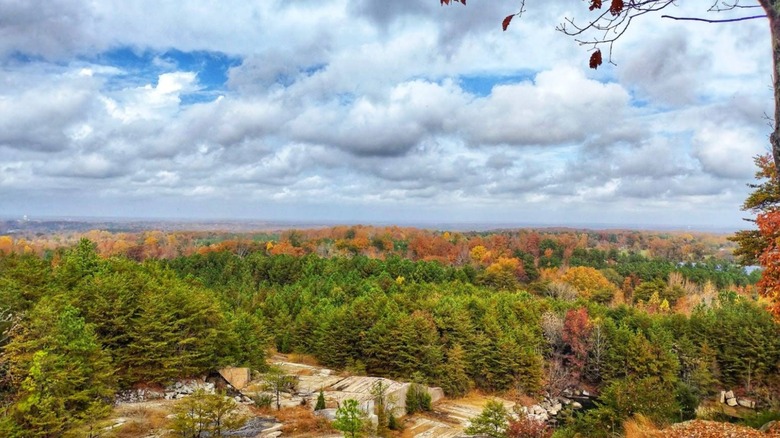 Fall foliage surrounds abandoned quarry and cloudy sky Dunn's Mountain Park