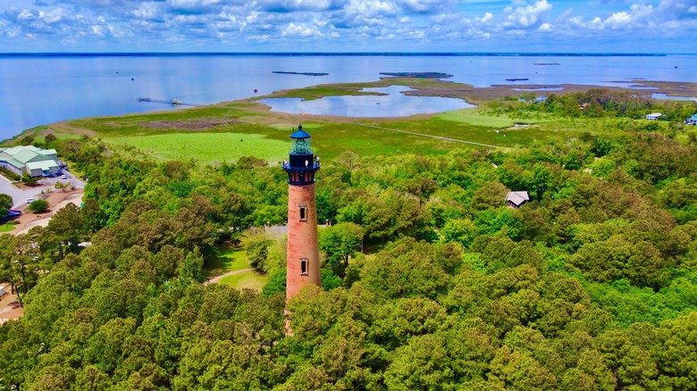 The Currituck Lighthouse surrounded by marshes, forest, and the Currituck Sound