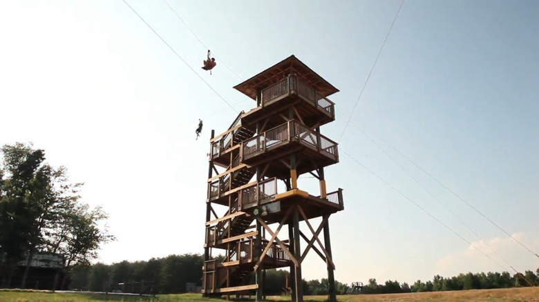 A zipline tower featuring zipliners at Kersey Valley Attractions in Archdale, North Carolina.