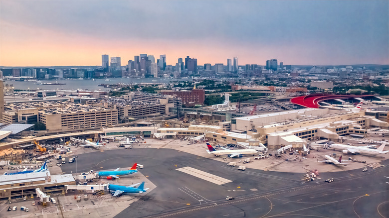 Boston Logan Airport tarmac with airplanes and the Boston city skyline in the background