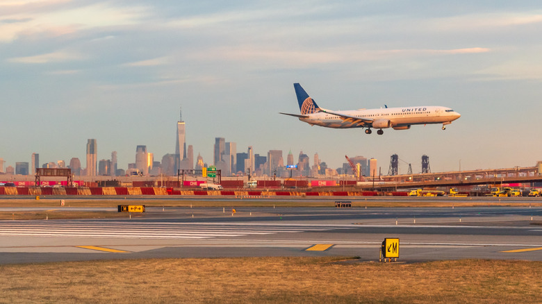 A United passenger jet comes in for a landing in front of the New York City skyline at Newark Liberty Airport