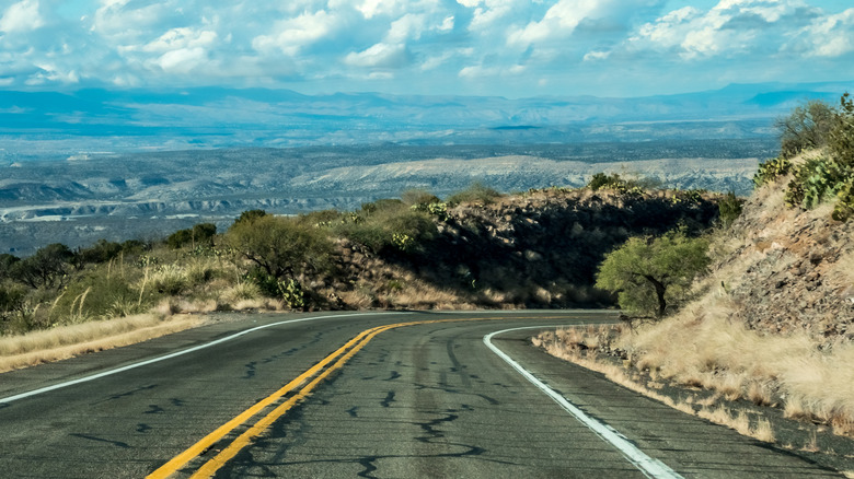 A road with Arizona's Mogollon Rim in the distance