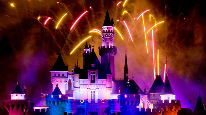 Nighttime view of the Castle of Magical Dreams, the centerpiece of Hong Kong Disneyland resort in Hong Kong, illuminated and with fireworks above