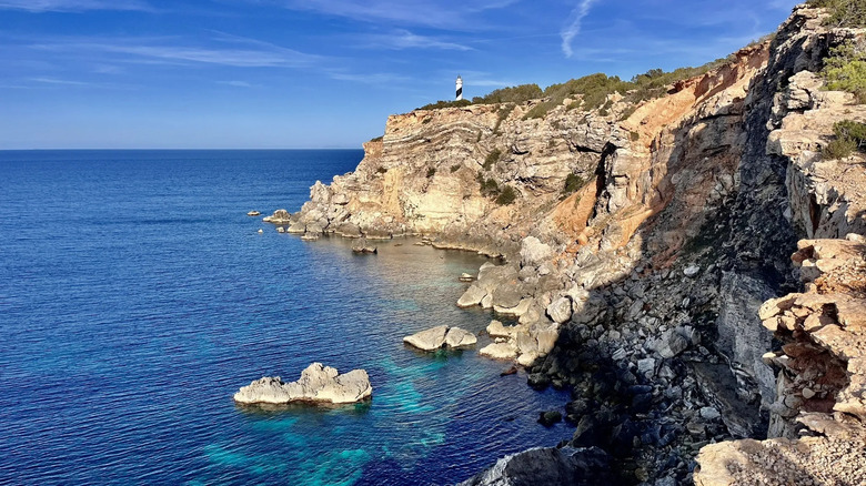view of a lighthouse from a hiking trail on Ibiza