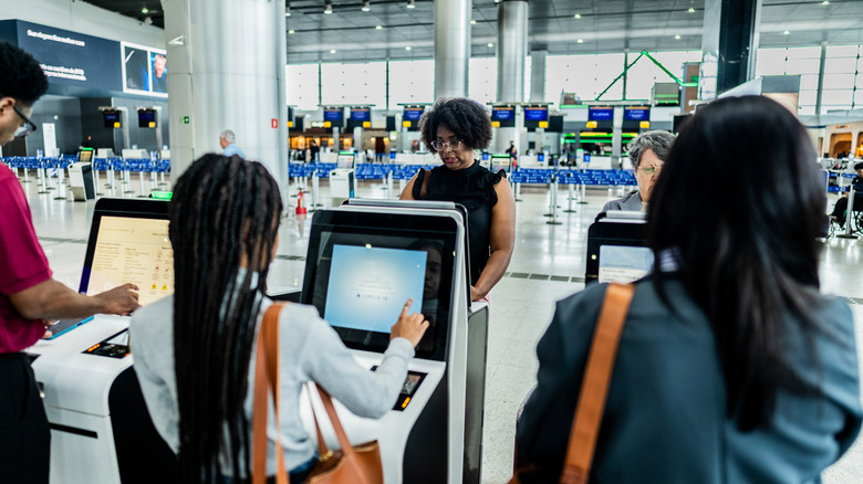 People checking in at airport kiosks