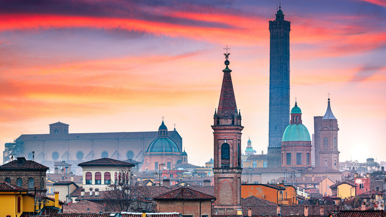 Bologna, Italy rooftop skyline and famous historic towers at dusk.