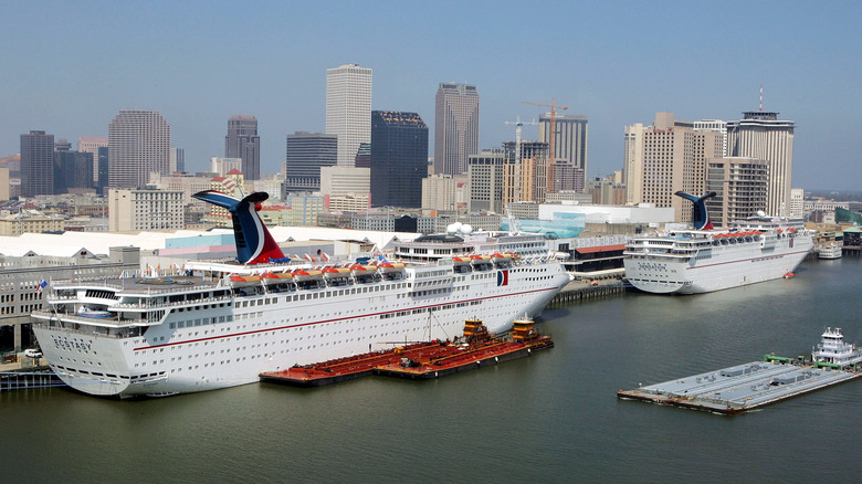 Several large cruise ships docked in front of the New Orleans skyline