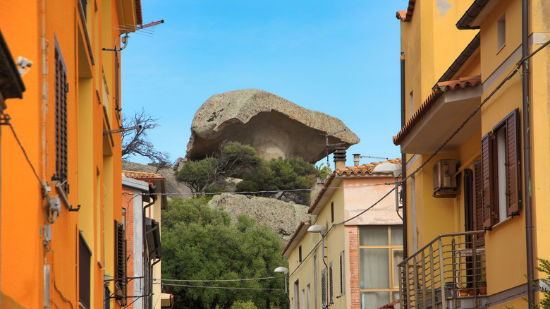 Mushroom Rock between colorful buildings in Arzachena, Italy