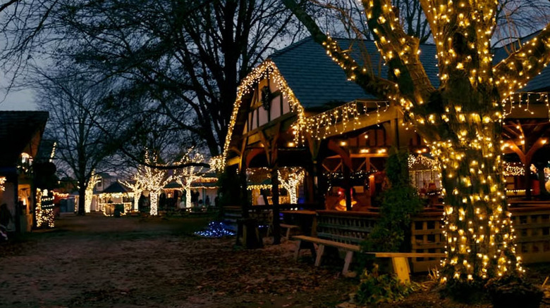 Buildings in the Yuletide Village decorated for Christmas, surrounded by trees covered in white lights