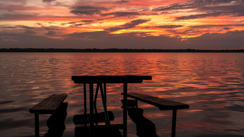 Colorful sunset behind a picnic table submerged in water at Alum Creek State Park, OH