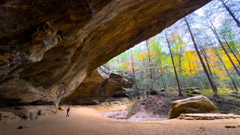 Ash Cave's massive ledge dwarfs an exploring visitor, Hocking Hills State Park, OH