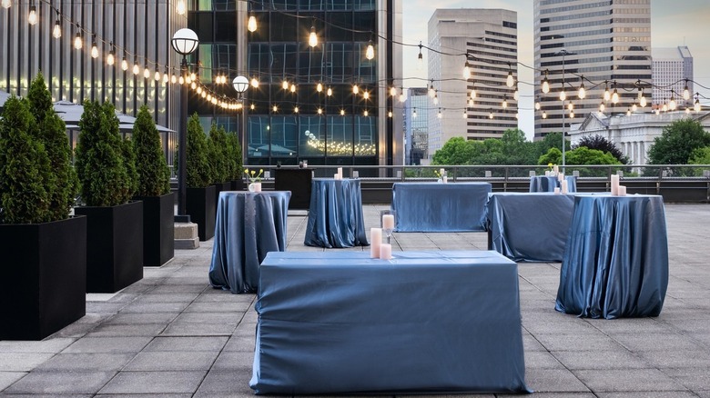 A rooftop terrance with cocktail tables