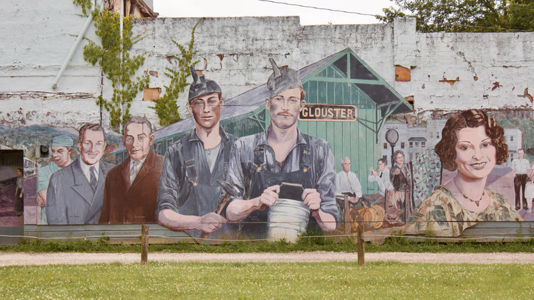 A mural depicting a historical train, local figures, and buildings, celebrating the heritage of Glouster, Ohio