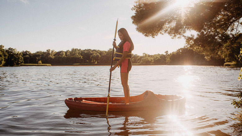 Woman paddleboarding at sunset on a lake