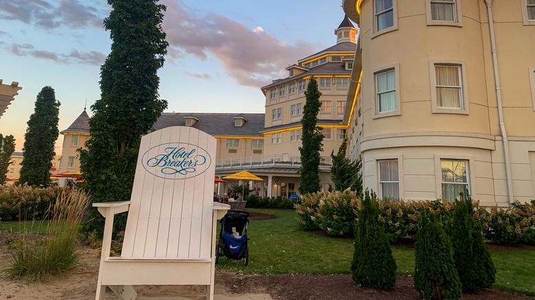 Lake-facing side of Hotel Breakers with green landscaping and beach chair on sand