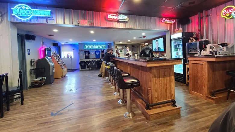 The wood interior of JimBo's with neon beer brand signs on the walls
