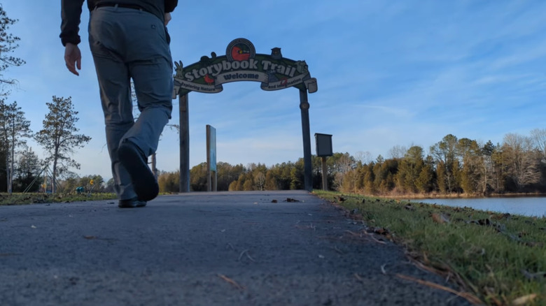 A person approaches the sign for Storybrook Trail