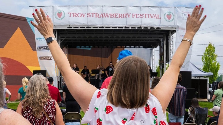 Woman raising her arms during a concert at the Troy Strawberry Festival