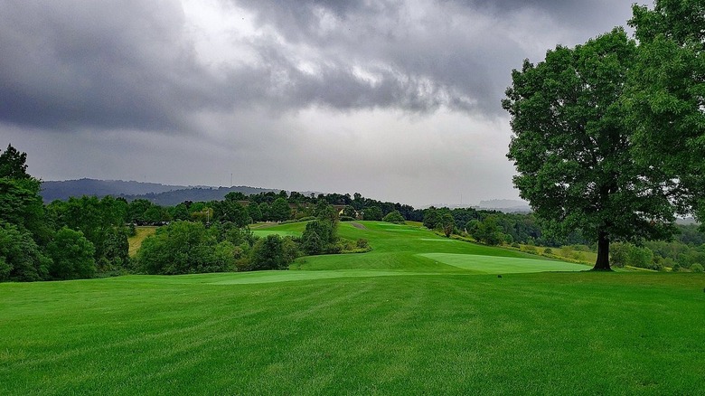 An expansive golf field at the Virtues Golf Club, with clouds overhead