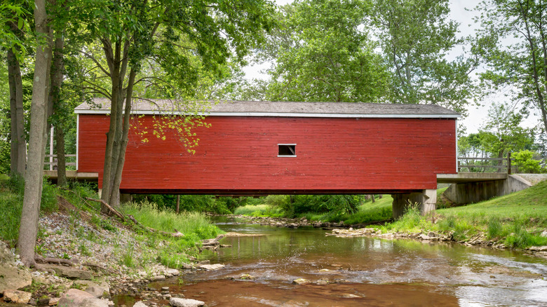 Bright red covered bridge over creek